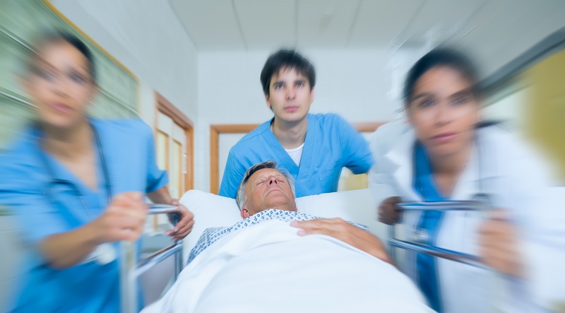 Team of doctor running in a hospital hallway with a patient in a bed
